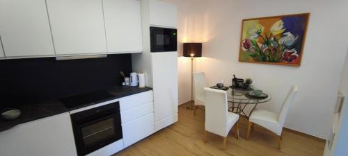 une cuisine avec une table et des placards blancs ainsi qu'une salle à manger dans l'établissement Smart home Sébastien, à Kastav