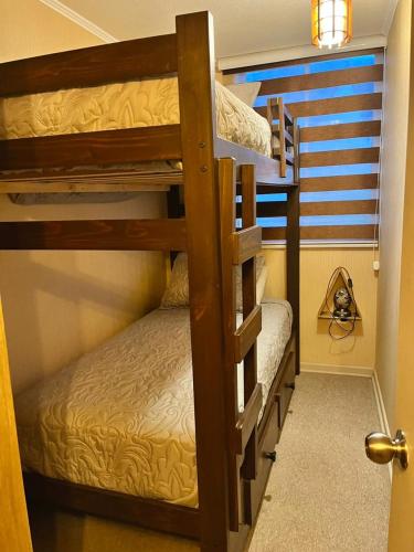 a couple of bunk beds in a room at Excelente Departamento en Penco, cerca de la playa, del centro y de la plaza in Penco