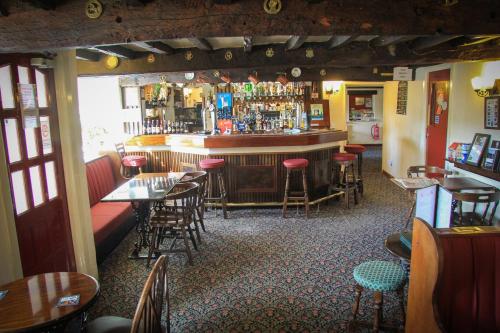 a restaurant with a bar with tables and chairs at The Red Lion in Lowick Green