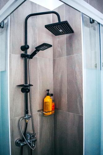 a shower with a yellow soap bottle on a shelf at Premium Sun Apartment in Vokolidha
