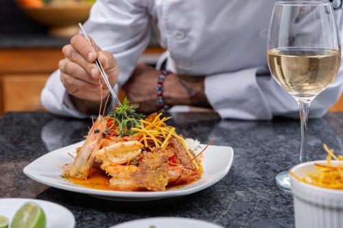a person sitting at a table with a plate of food at Jama Campay - Homes Resort & Spa in Jama