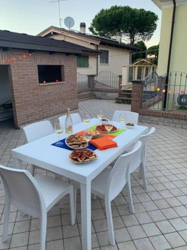 a white table with white chairs and food on it at Villa Parisi, Fano, Marche, Italian Villa in Fano