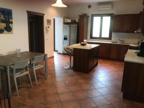 a kitchen with a table and chairs and a table and a kitchen with a counter at Villa Parisi in Fano