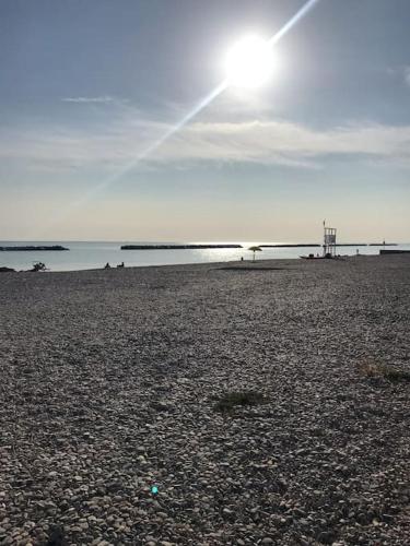 a sandy beach with the sun in the sky at Villa Parisi, Fano, Marche, Italian Villa in Fano