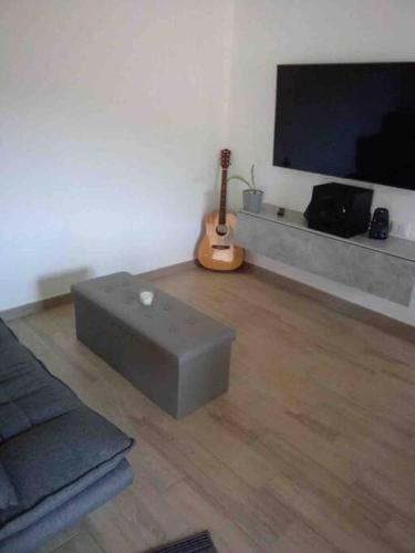 sala de estar con sofá y guitarra en Casa Vacanze a 10 km dal mare en Carbonia