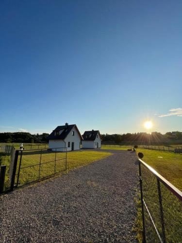 a farm with a white house and a fence at Białe Domki in Bytów