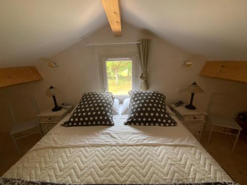 a bedroom with a bed with pillows and a window at Gite Wildflower Lane in Valojoulx