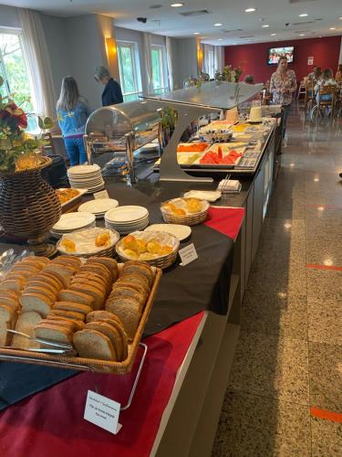 a buffet line with bread and pastries on display at Flat com Vista Panorâmica na Barra da Tijuca in Rio de Janeiro