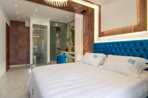 a bedroom with a large bed with a blue headboard at Pela Veranda Exquisite Suites in Neos Marmaras