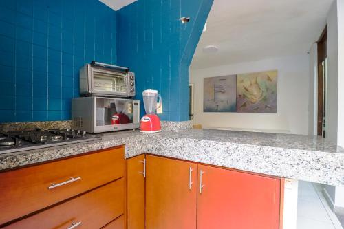 a blue kitchen with a counter top and a microwave at Hostal en El Centro LaKiwa in Mazatlán