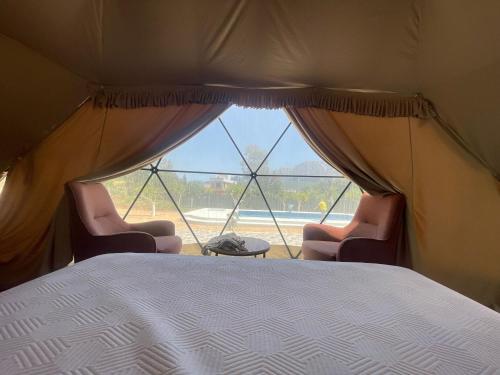 a bedroom with two chairs and a bed and a window at Yeşilçam Glamping in Antalya