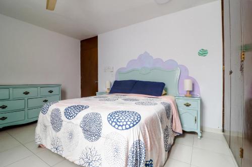 a bedroom with a blue and white bed and a dresser at Hostal en El Centro LaKiwa in Mazatlán