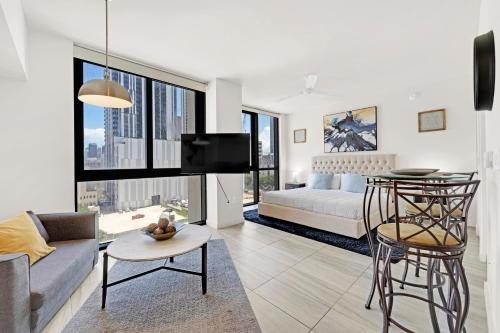 a living room with a couch and a bed and a tv at Devereaux Miami Luxury One-Bedroom and Studios in Miami