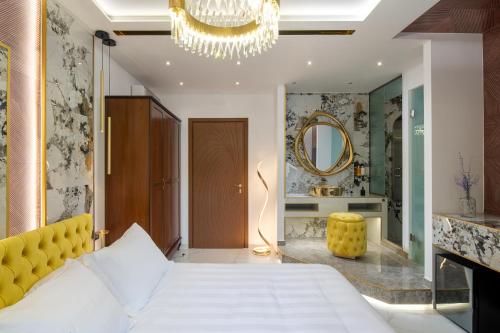 a bedroom with a white bed and a mirror at Pela Veranda Exquisite Suites in Neos Marmaras