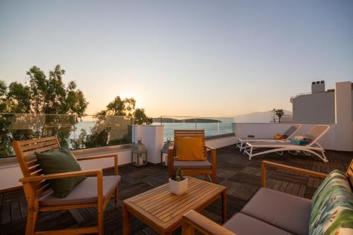 a balcony with chairs and tables and a view of the ocean at Aurelia Sea View Loft Suite in Agios Nikolaos