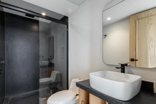 a bathroom with a sink and a toilet and a mirror at ULIV Antara in Mexico City