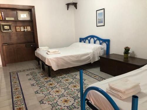una camera con due letti e un tavolo con asciugamani di Isola - LIPARI centro storico a Città di Lipari