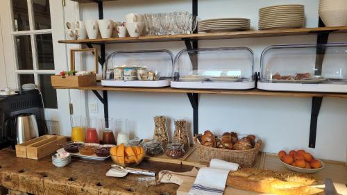 a table with plates and other items on shelves at Chambres d'Hôtes du Marché aux Grains in Bouxwiller