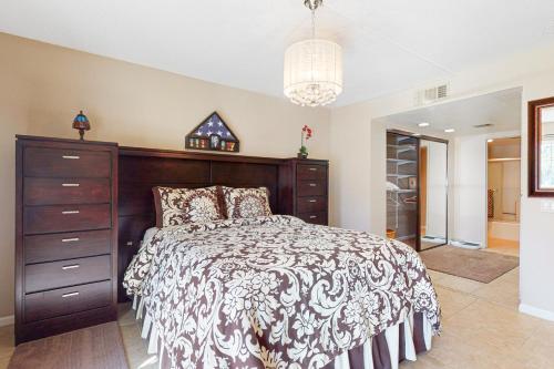 a bedroom with a large bed and a dresser at Mesquite Chic Retreat Permit# 3160 in Palm Springs