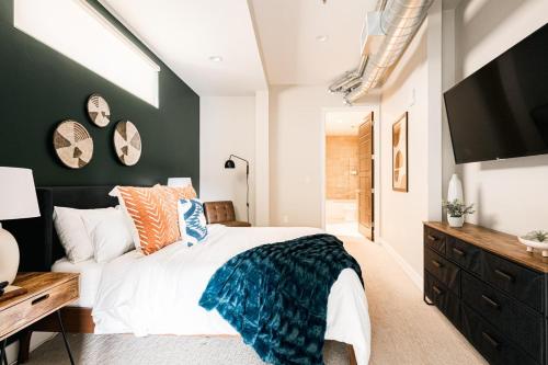 1 dormitorio con 1 cama grande y TV en Modern Industrial Loft - Center of RiNo Art District en Denver