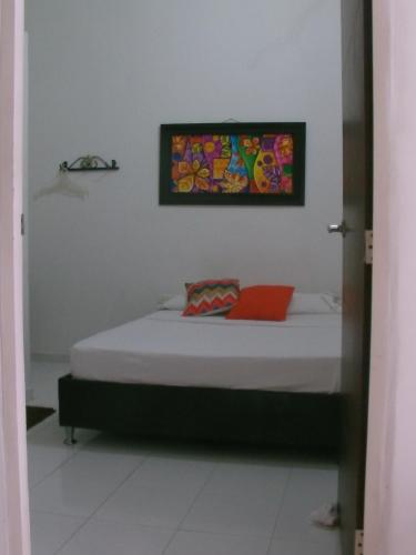 a bed in a room with a painting on the wall at Hotel Nicole in Girardot