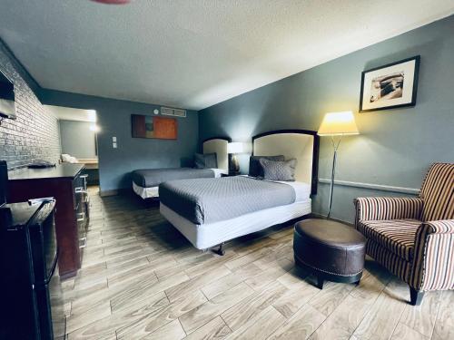 a hotel room with two beds and a chair at Extended Stay SA in San Antonio