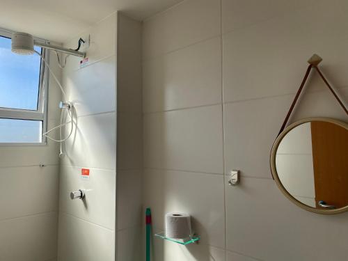 uma casa de banho com um espelho e um chuveiro em Apês Palmeira Dourada - Centro de Palmas e Aromaterapia em Palmas