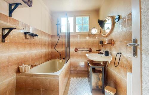 a bathroom with a bath tub and a sink at Pet Friendly Home In Touffreville With Kitchen in Touffreville