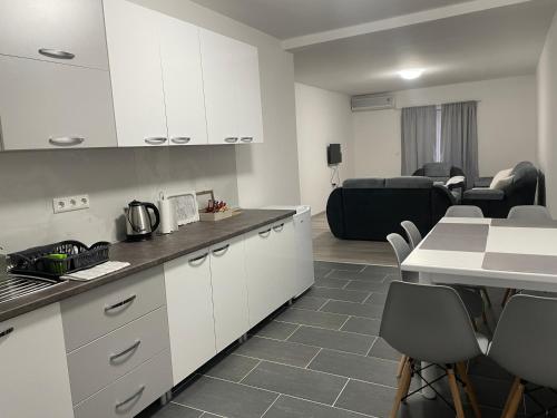 eine Küche mit weißen Schränken und ein Wohnzimmer in der Unterkunft Apartmani Franciska in Jajce