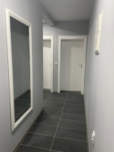 a hallway with two mirrors and a tiled floor at Apartmani Franciska in Jajce