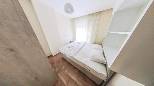 a small bedroom with a bed and a window at Cozy flat close to Konyaaltı beach '6' in Antalya