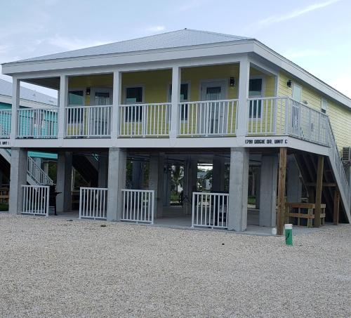 a large yellow house with a large balcony at Old Wooden Bridge Resort & Marina in Big Pine Key