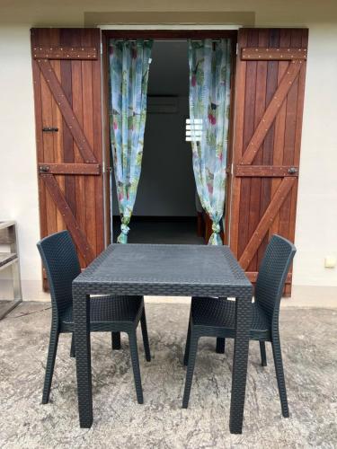 un tavolo nero e delle sedie davanti a una porta di Chambre Paradise a Lamentin