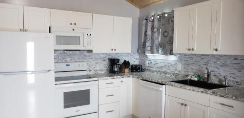 una cocina blanca con electrodomésticos blancos y armarios blancos en Old Wooden Bridge Resort & Marina, en Big Pine Key