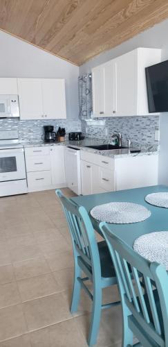 una cocina con mesa y sillas y una cocina con armarios blancos. en Old Wooden Bridge Resort & Marina, en Big Pine Key