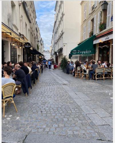 um grupo de pessoas sentadas em cadeiras em uma rua em La Résidence Panthéonique em Paris