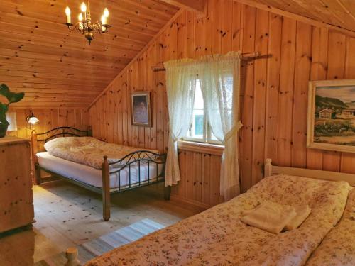 Un dormitorio con dos camas en una cabaña de madera. en Unique farm stay in the steep mountains of Rjukan, en Vemork