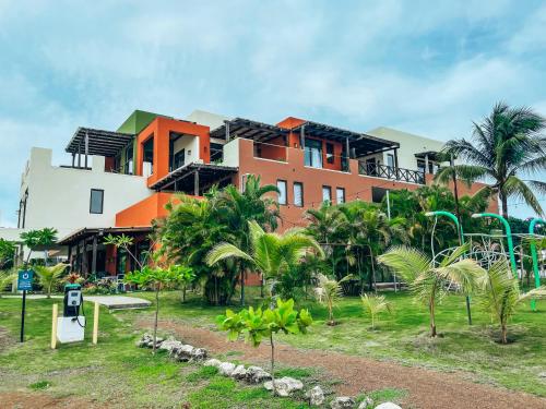 a building with palm trees in front of it at El Sitio Village in Playa Venao