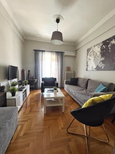 een woonkamer met een bank en een tafel bij Mario's comfortable local apartment, next to metro station, close to Acropolis in Athene