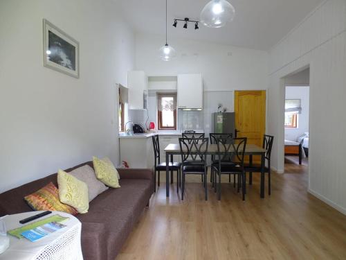 a living room with a couch and a table with chairs at CasaMisur in Puerto Varas