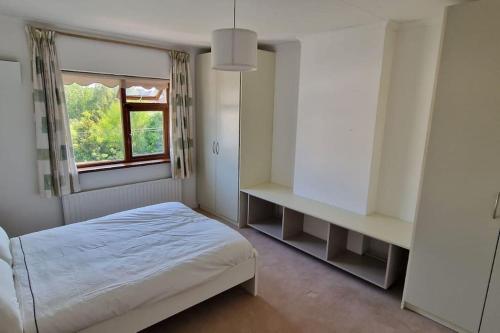 a white bedroom with a bed and a window at Home in Monkstown in Monkstown