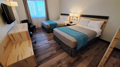 a hotel room with two beds and a television at Hotel Diego de Almagro Viña del Mar in Viña del Mar