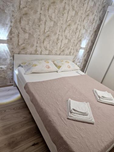 a bedroom with a bed with towels on it at Apartments Julijana 2 in Privlaka