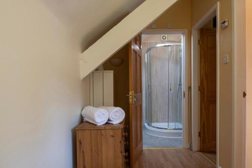 Baño con 2 toallas sobre una mesa de madera en The Coachhouse - Cottage with Private Hot tub, en Colwyn Bay