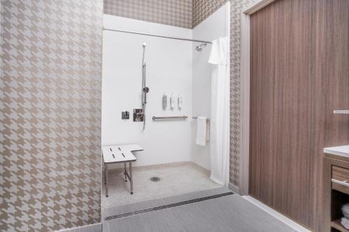 a bathroom with a shower with a bench in it at Home2 Suites By Hilton Lake Havasu City in Lake Havasu City