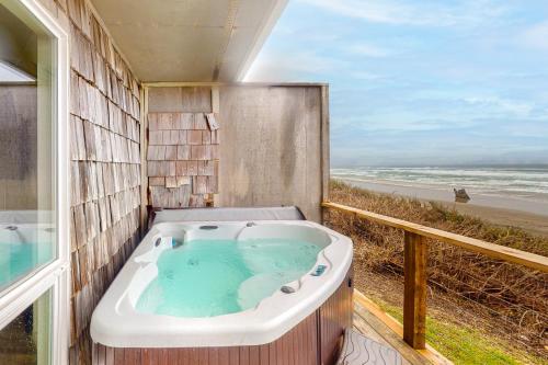 a bath tub with a view of the beach at Cape Cod Cottages - Unit 9 in Waldport