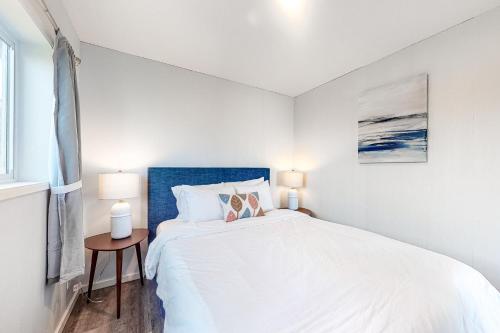 a white bedroom with a large bed and a window at Cape Cod Cottages - Unit 9 in Waldport