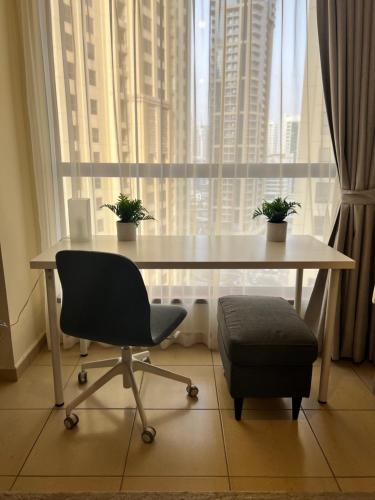 a table with two plants on it in front of a window at Robin Beach Hostel JBR in Dubai