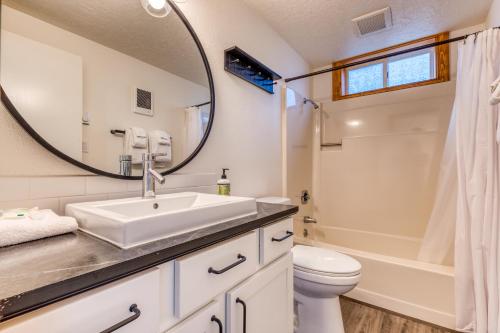 a bathroom with a sink and a toilet and a mirror at Cape Cod Cottages - Unit 8 in Waldport