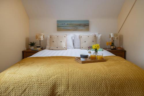 a bedroom with a bed with a tray with flowers on it at The Coachhouse - Cottage with Private Hot tub in Colwyn Bay